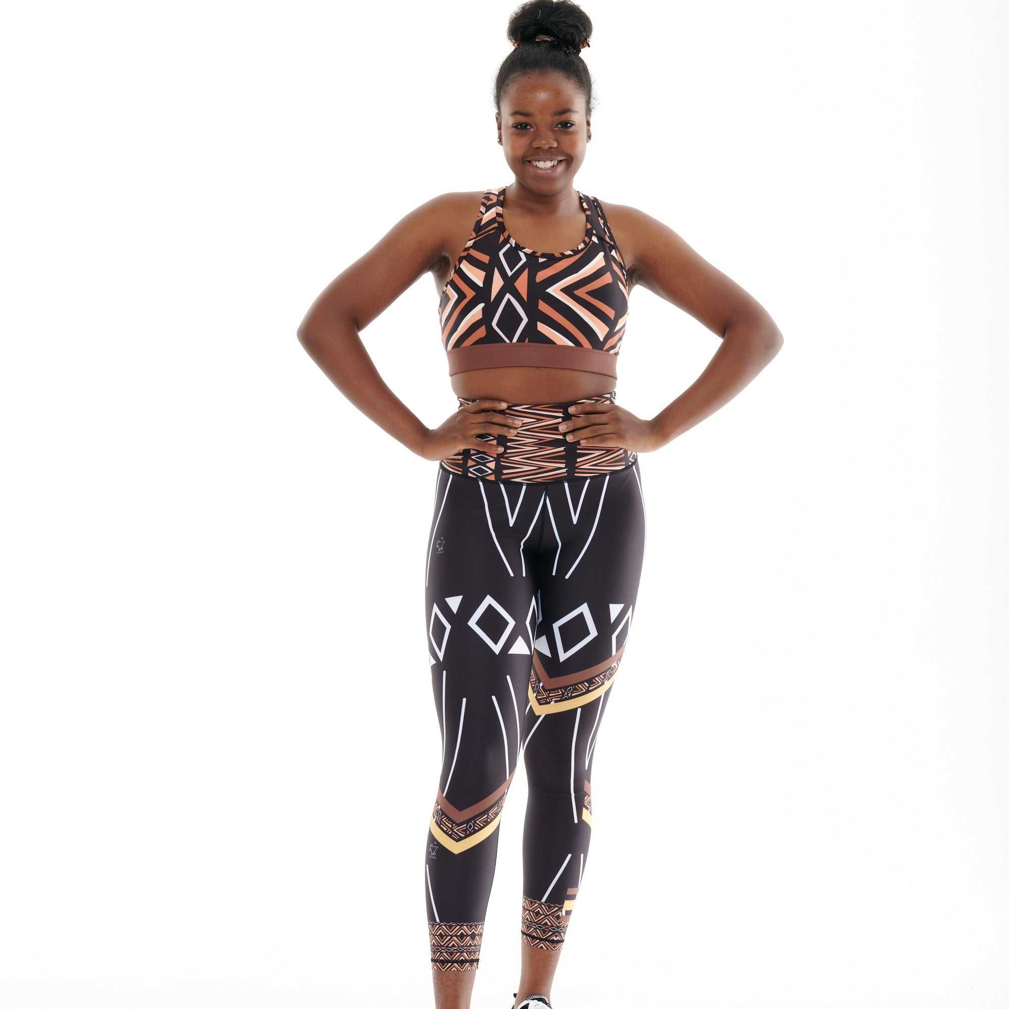 Ibeekay Splash Leggings featuring tribal-inspired Bògòlanfini Mud Cloth print in brown, orange, black, and white.
