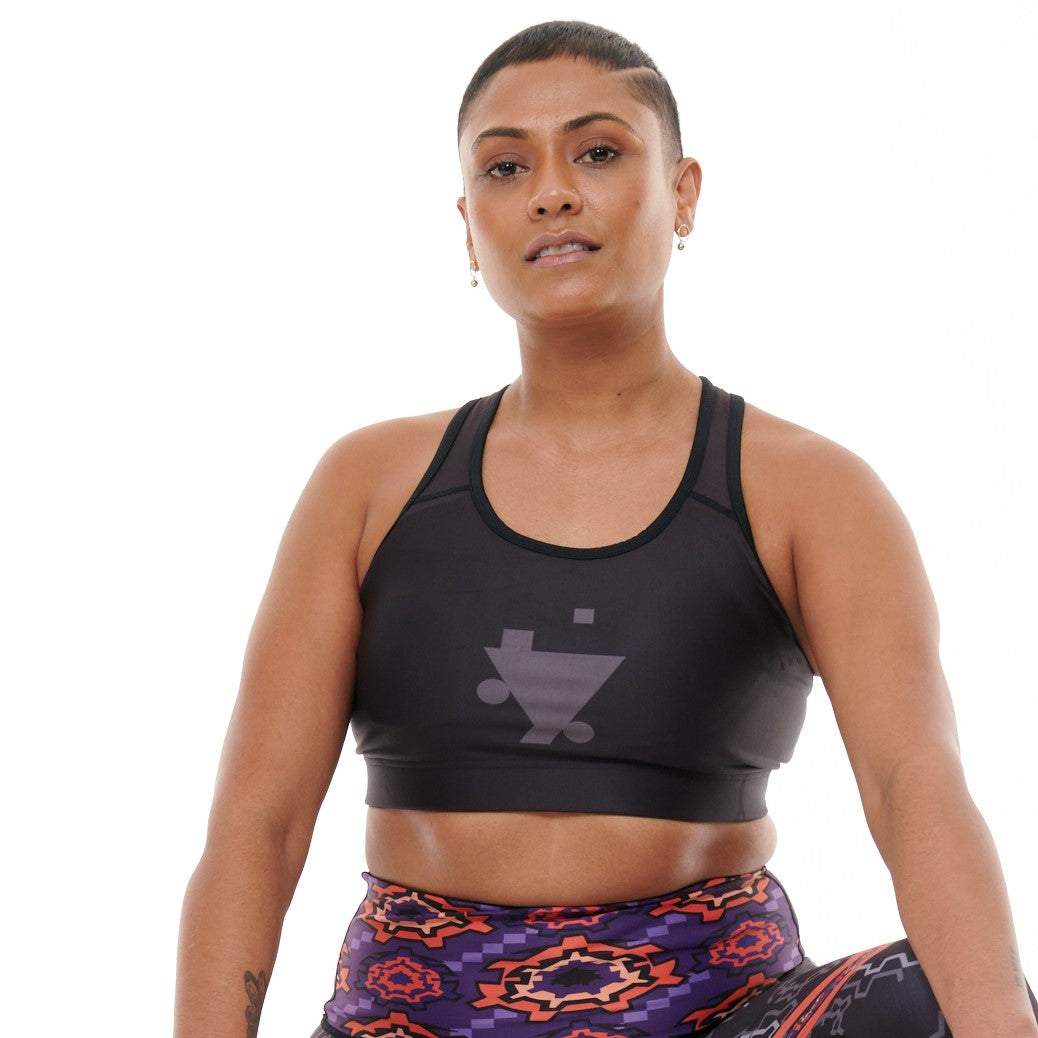 B.G.W.E Sports Bra by TYNA, medium support, black, paired with vibrant leggings.