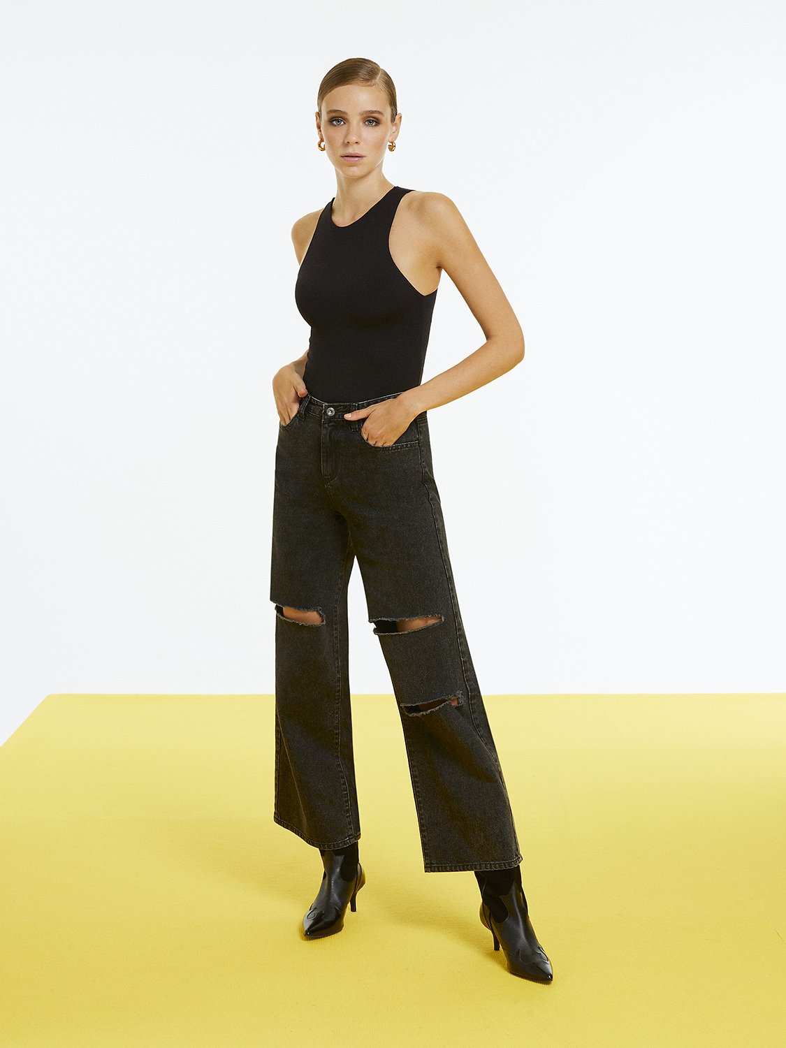 High-waisted ripped jeans with wide legs and rip detailing, featuring button and zip fly, side and back pockets.