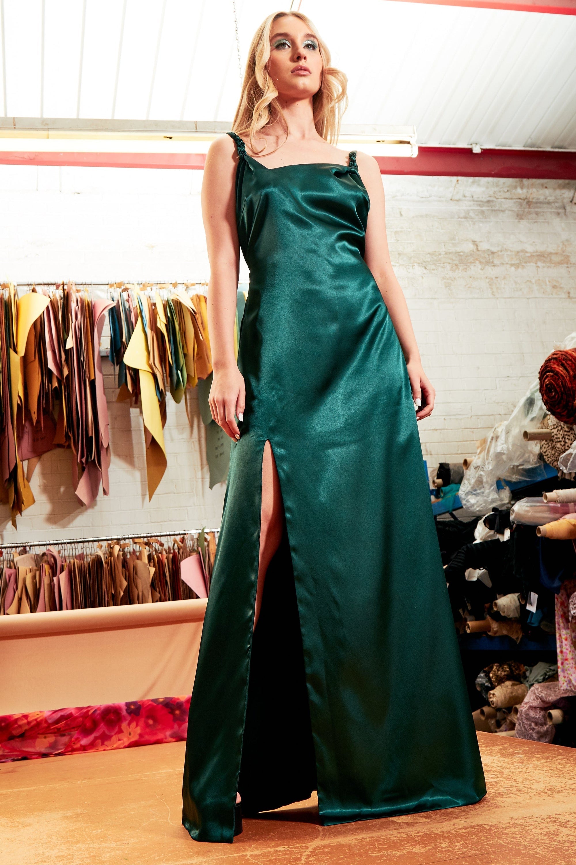 Emerald green satin backless maxi dress with twisted spaghetti straps and thigh-high slit.