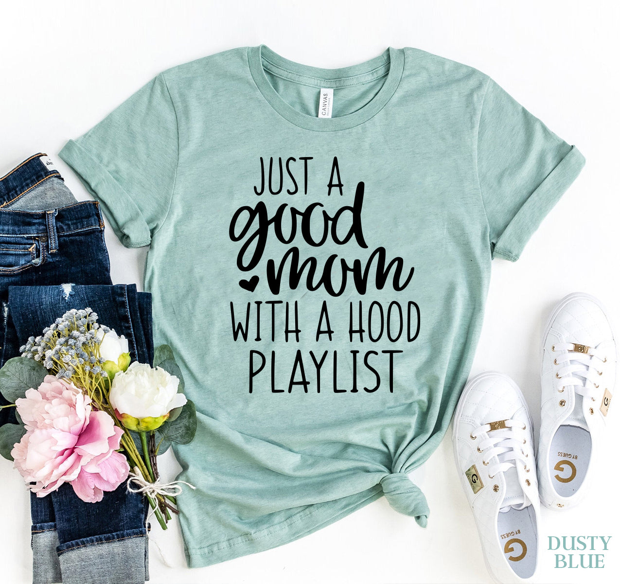 Good Mom t-shirt in mint green with playful text design, surrounded by casual jeans and sneakers.