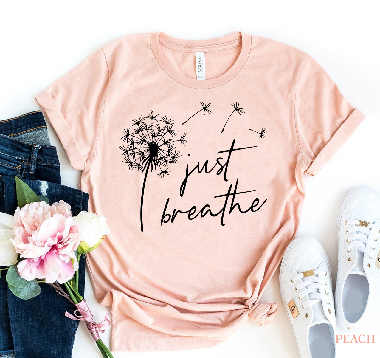 Peach-colored "Just Breathe" t-shirt with dandelion design, premium ring spun cotton, Bella Canvas brand.